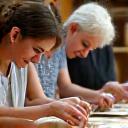 Gruppo di persone sorridenti che lavorano insieme la ceramica