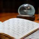 Donna che scrive su un quaderno con un vaso di vetro artistico in primo piano