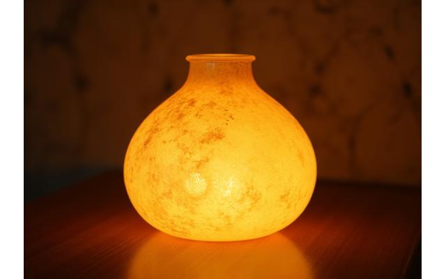 Lampada in vetro soffiato artigianale che emette luce soffusa e calda